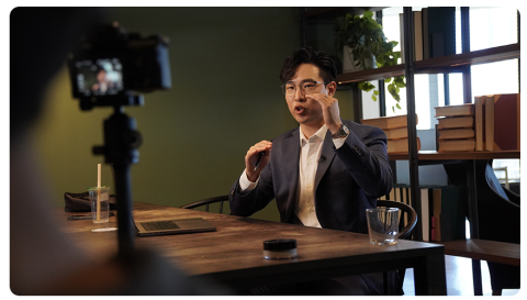 Dr Justin Sung teaching while seated at a desk and being recorded